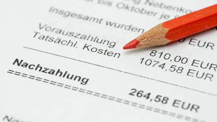 Roter Bleistift auf Nebenkostenabrechnung. Eine falsche NebenKostenabrechnung ist strafbar. Die Nachzahlung beträgt 264,58 EUR.